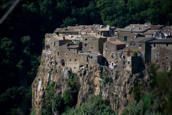 Spendita veduta della città di Calcata arroccata su una roccia.