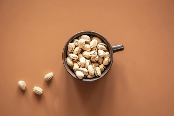 Flat lay, pistachios in a plate on a colored background.