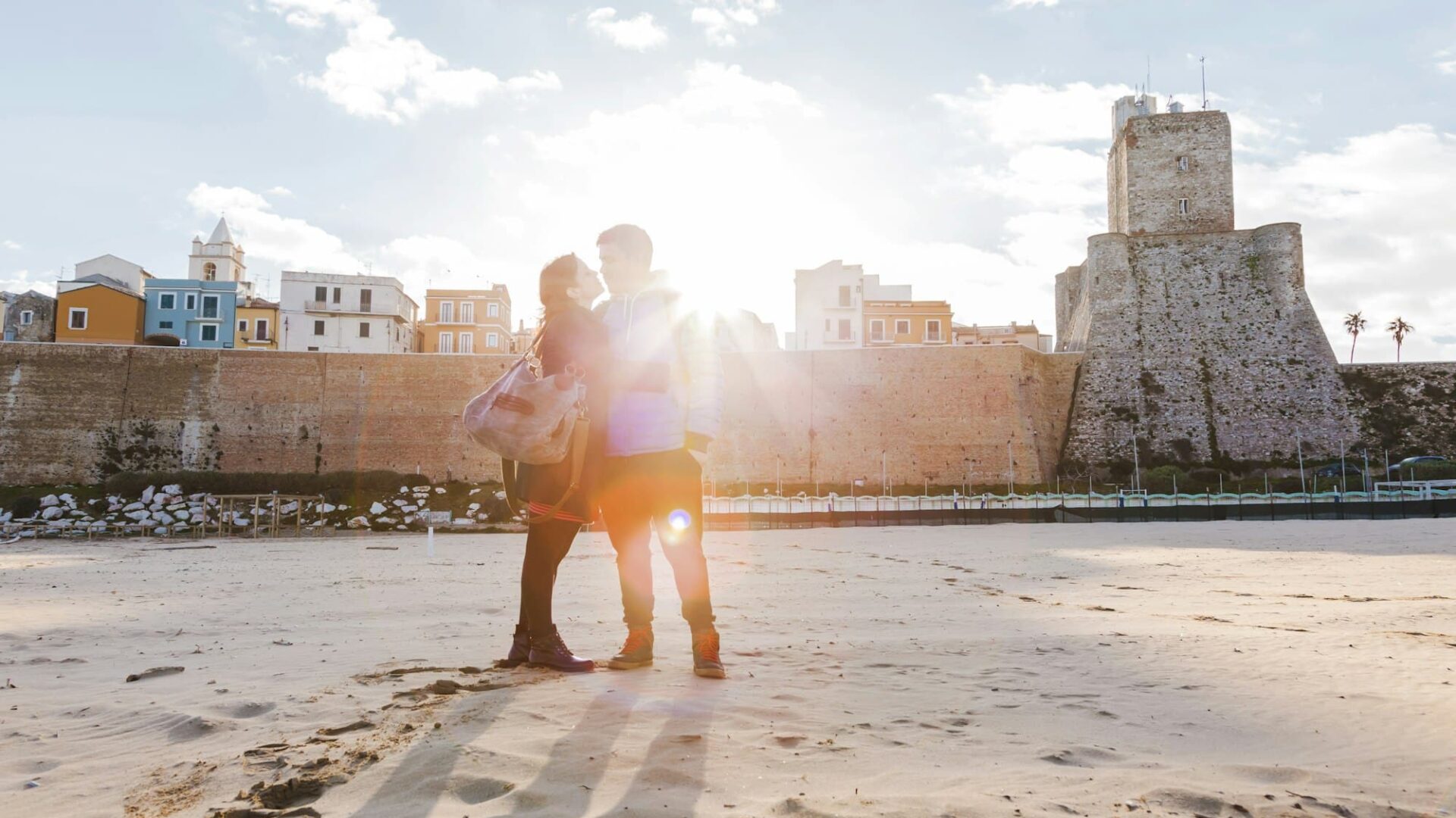 Italy, Molise, Termoli, young couple in the beach at sunrise