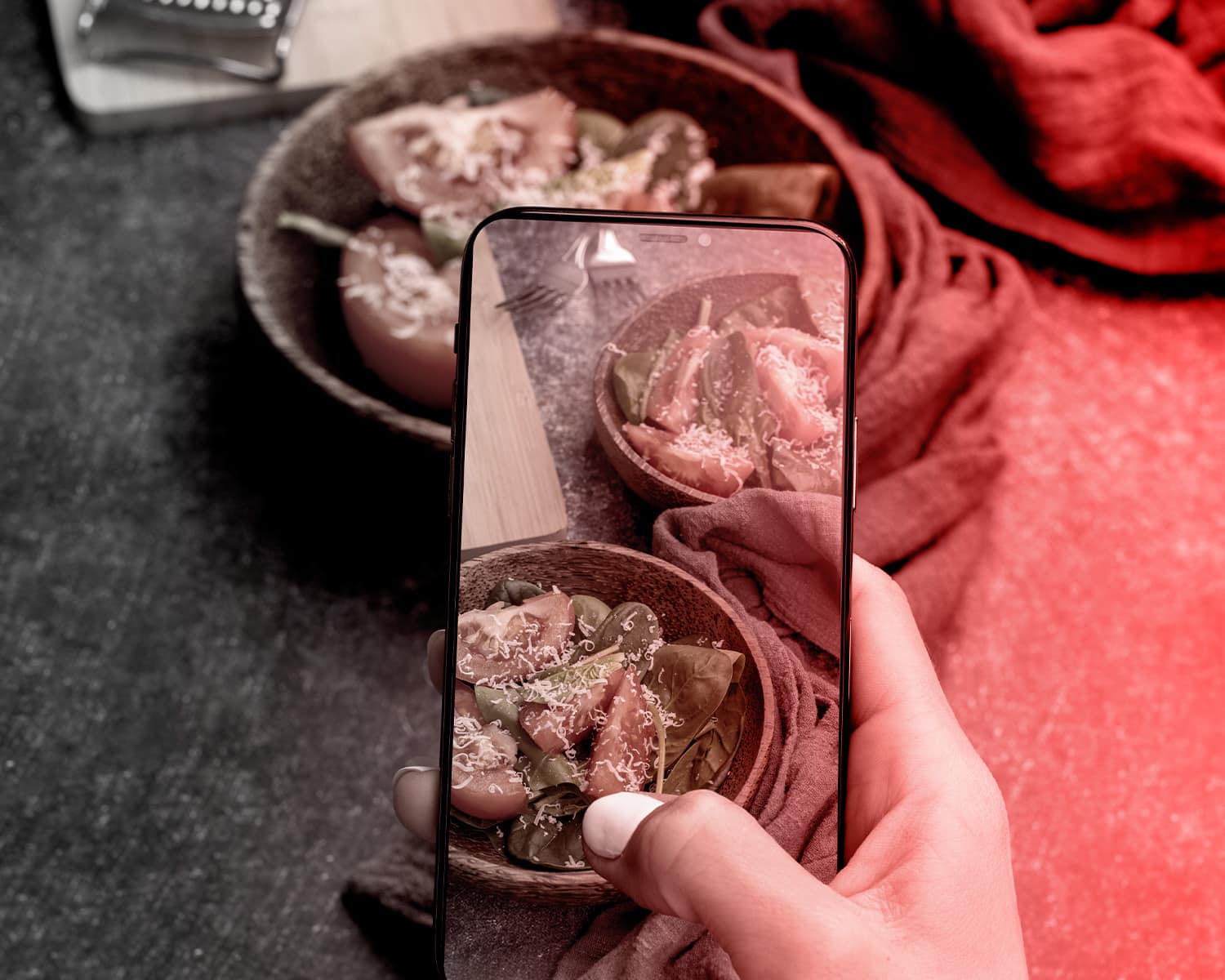 Toma de smartphone de ensalada fresca en cuenco de madera.