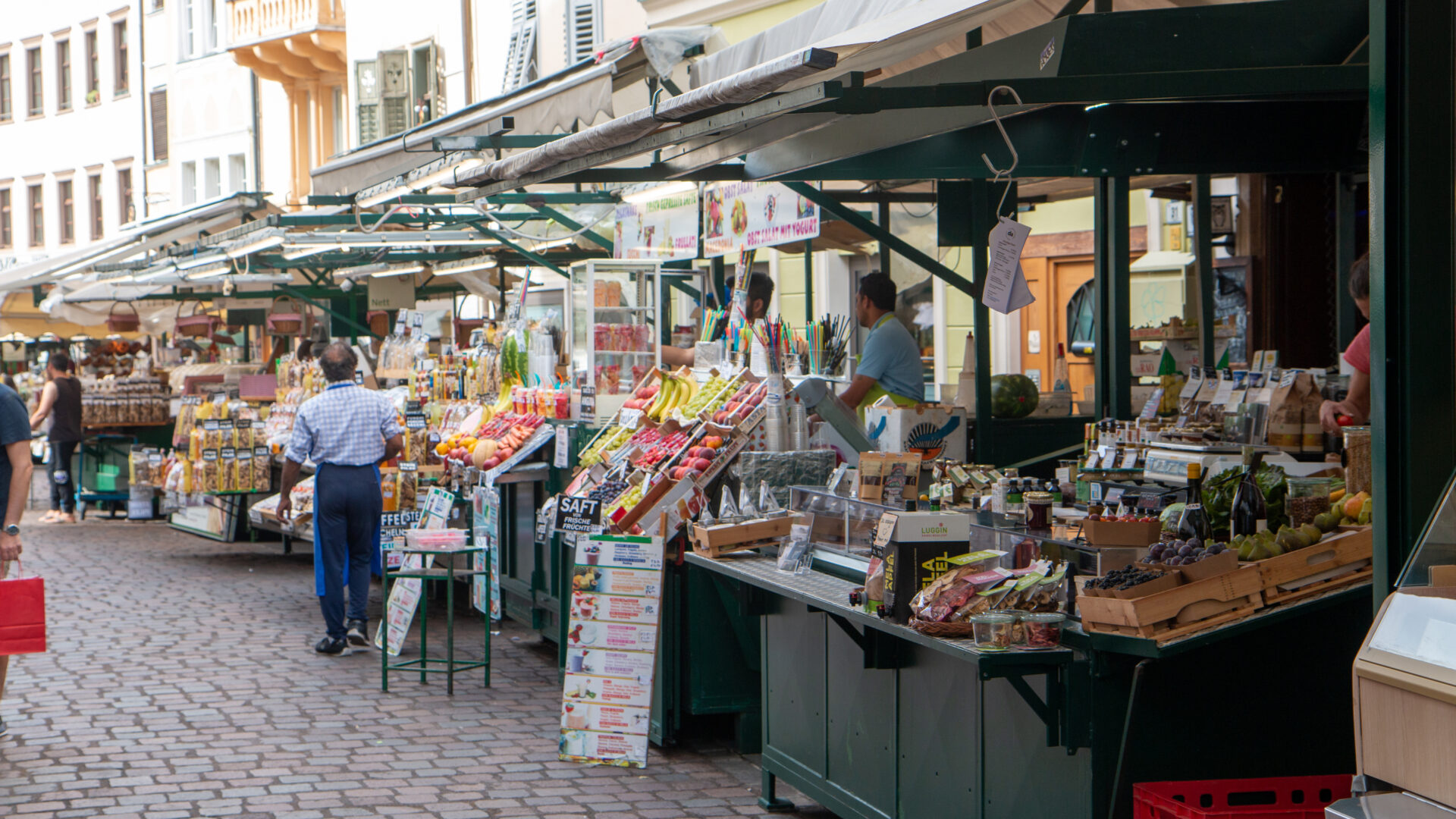 Mercato all'aperto con banchi di cibo.