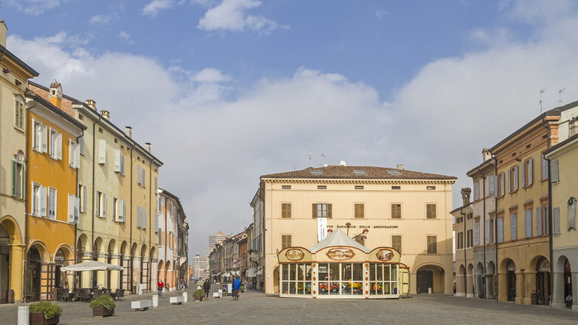 Piazza italiana con edifici colorati e cielo azzurro.