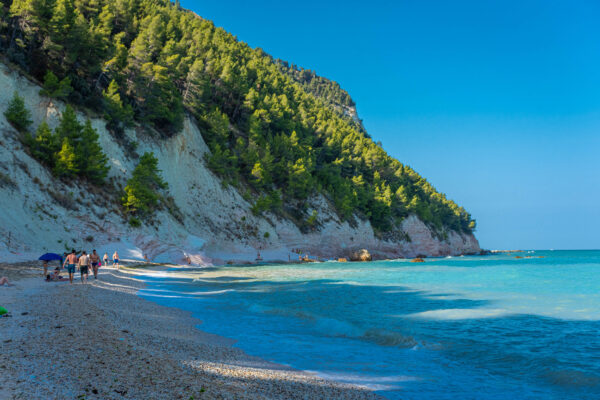 Beach with people and crystal clear sea.