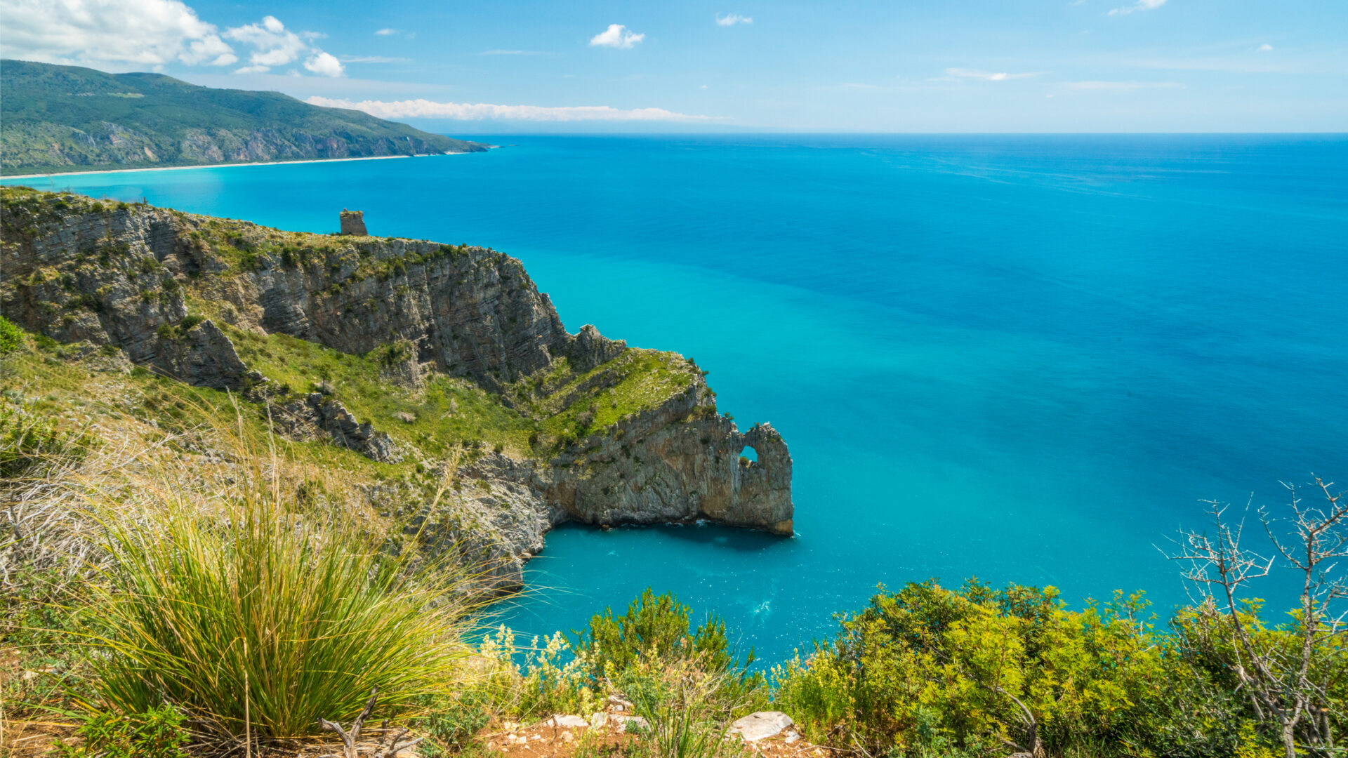 Scogliera e mare azzurro in una giornata soleggiata.