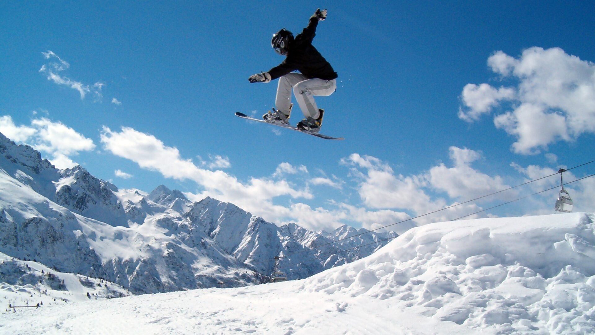Salto dello snowboarder (ragazza). Snowboarder che salta in aria nelle Alpi italiane