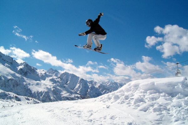 Snowboarder sautant (fille). Snowboarder sautant dans les airs dans les Alpes italiennes.