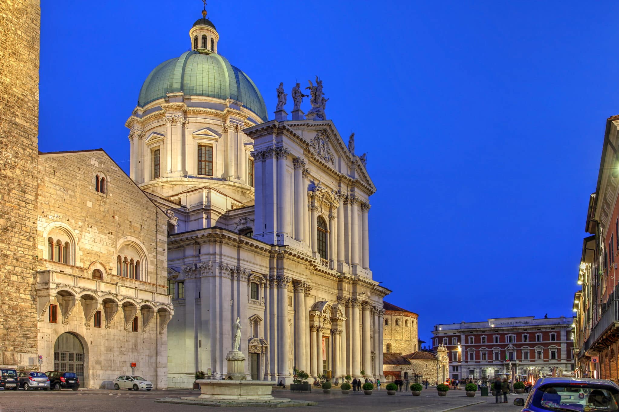 Scena notturna in Piazza Paolo VI, con il Municipio di Palazzo Broletto, il Duomo Nuovo Nuova Cattedrale e il Duomo Vecchio Cattedrale Vecchia o La Rotonda a Brescia, Italia