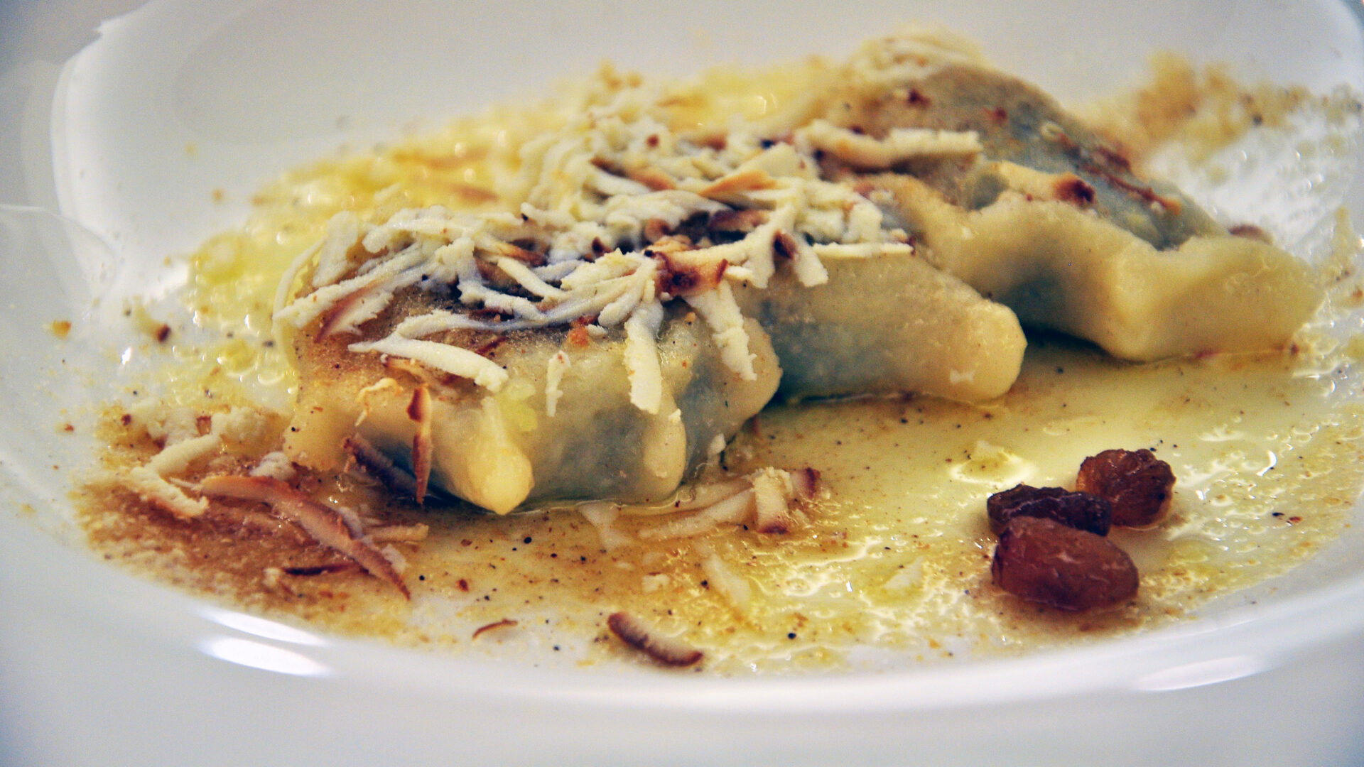 Raviolis caseros servidos con mantequilla y queso.