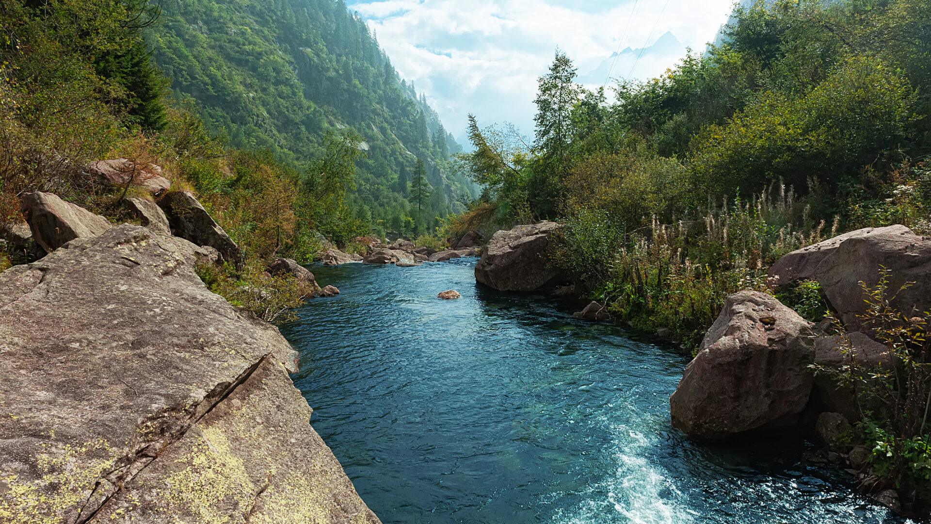 River between mountains and green vegetation.