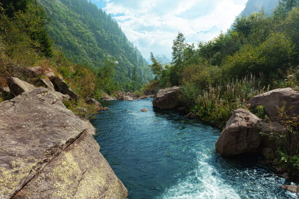 Fluss zwischen Bergen und grüner Vegetation.