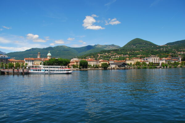 Lago, ciudad, montañas, barco, cielo azul, nubes.