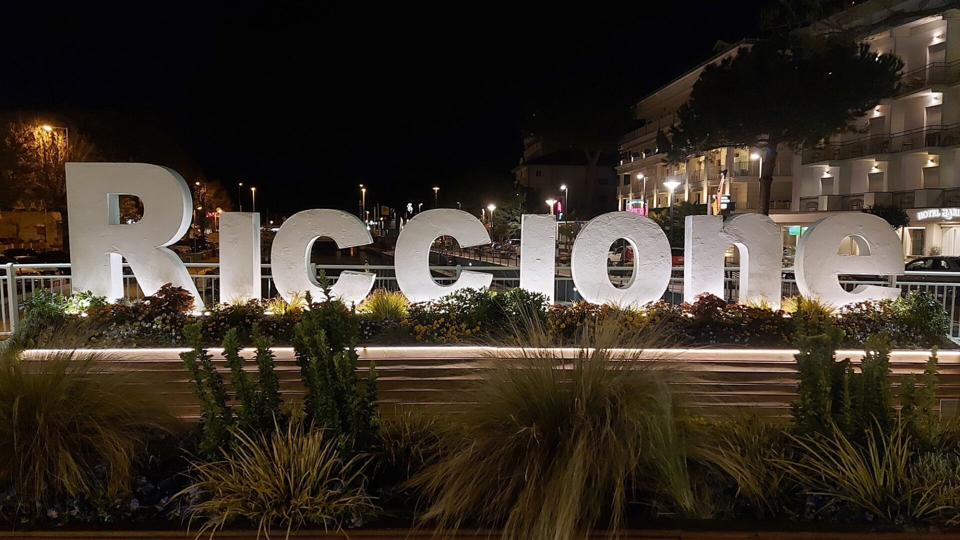 Cartello luminoso "Riccione" di notte.