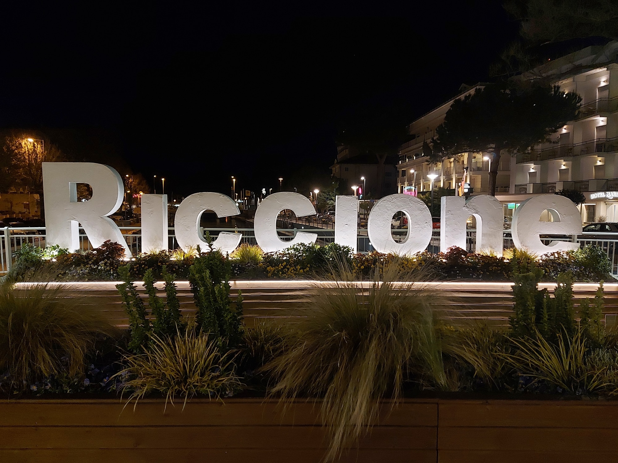 Cartello luminoso "Riccione" di notte.