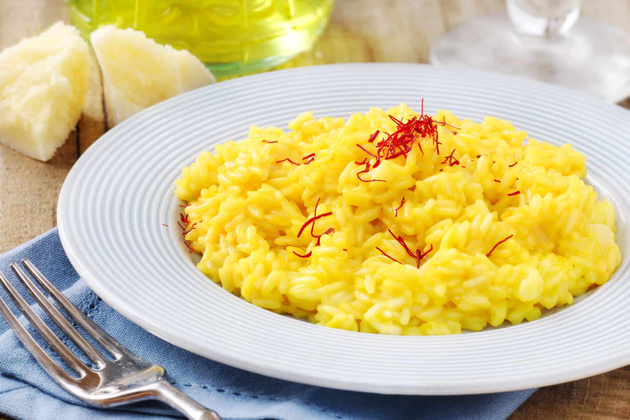 Risotto allo zafferano su un piatto bianco.