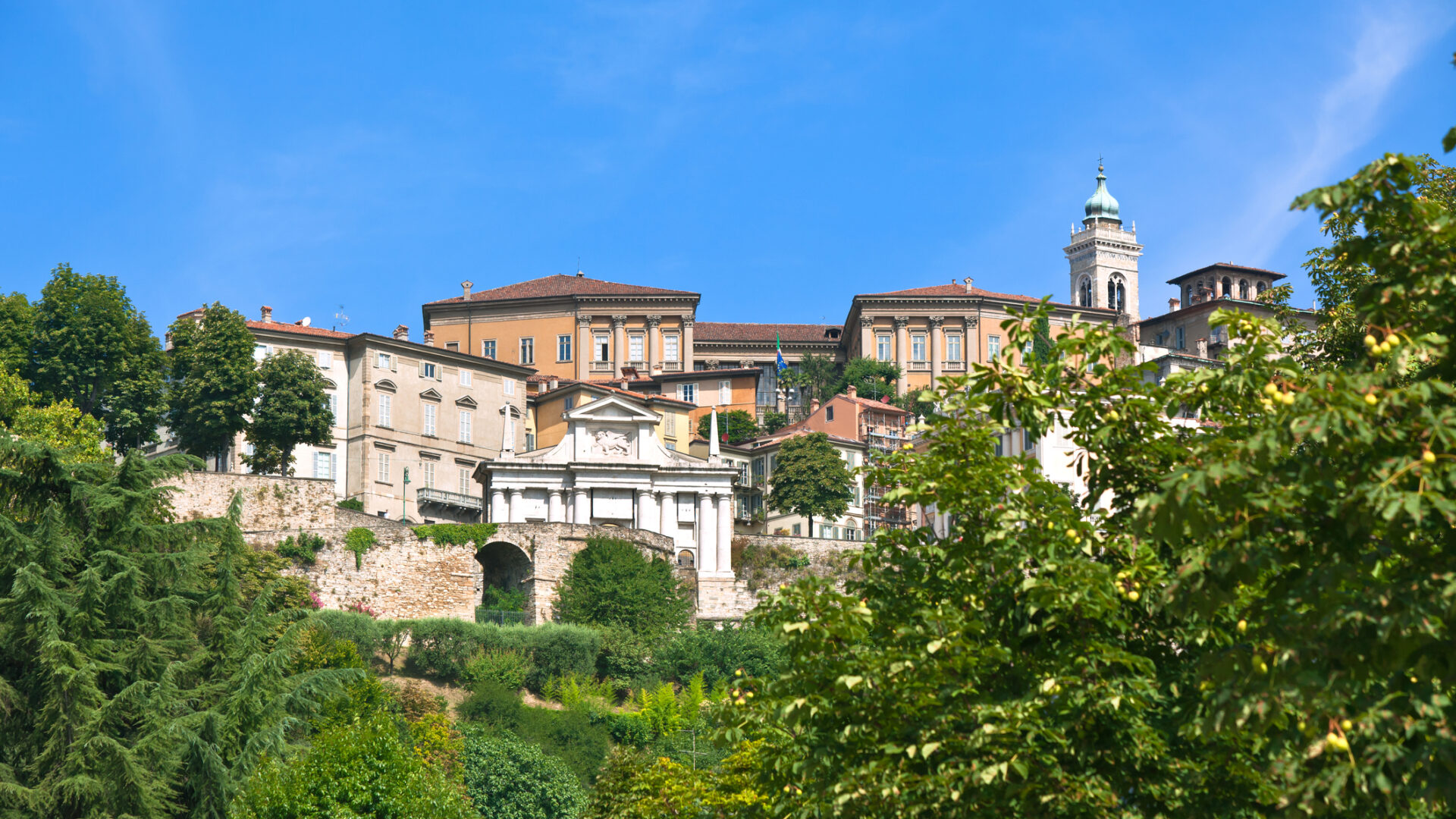 View of historic buildings on hill, blue sky.