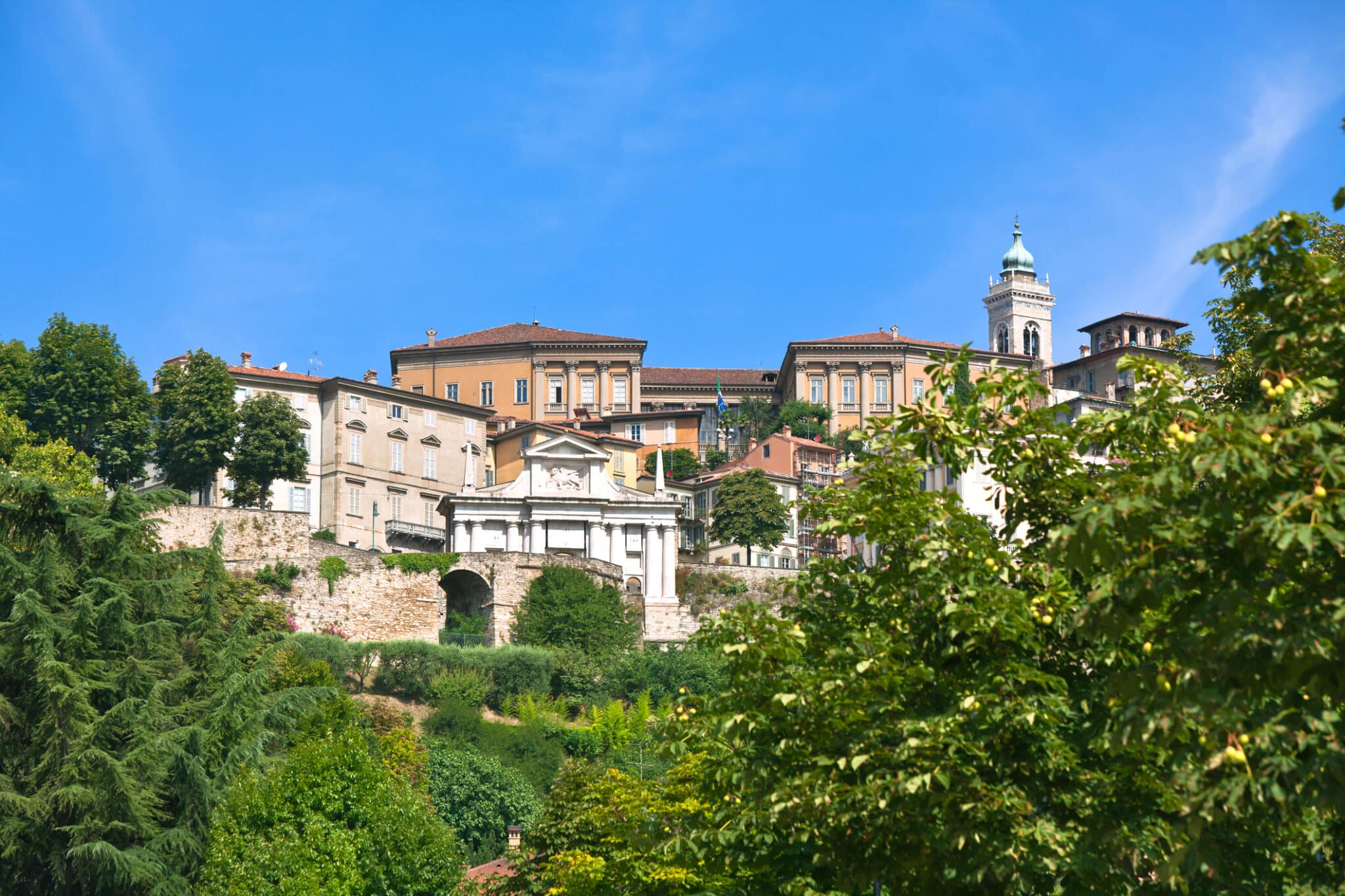 Vista di edifici storici su collina, cielo azzurro.