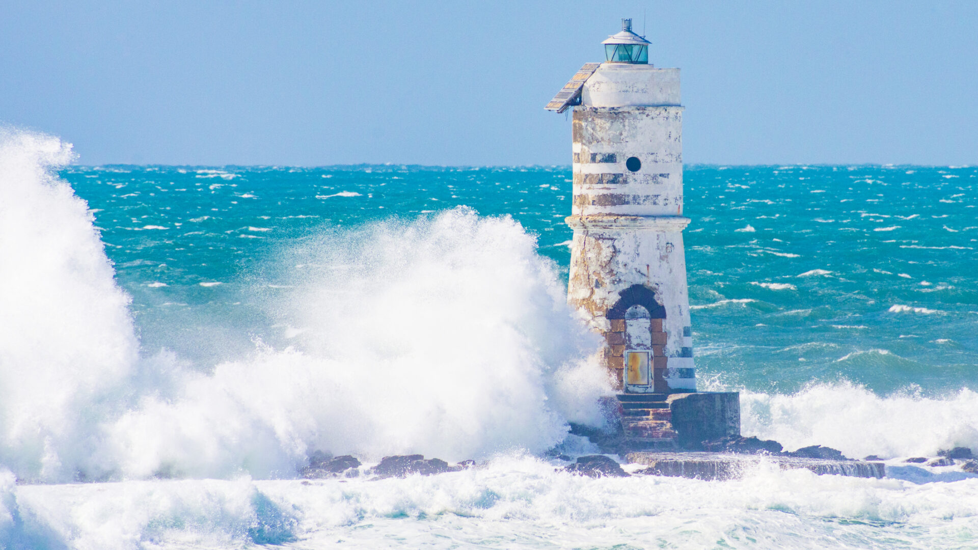 Lighthouse at sea with foamy waves
