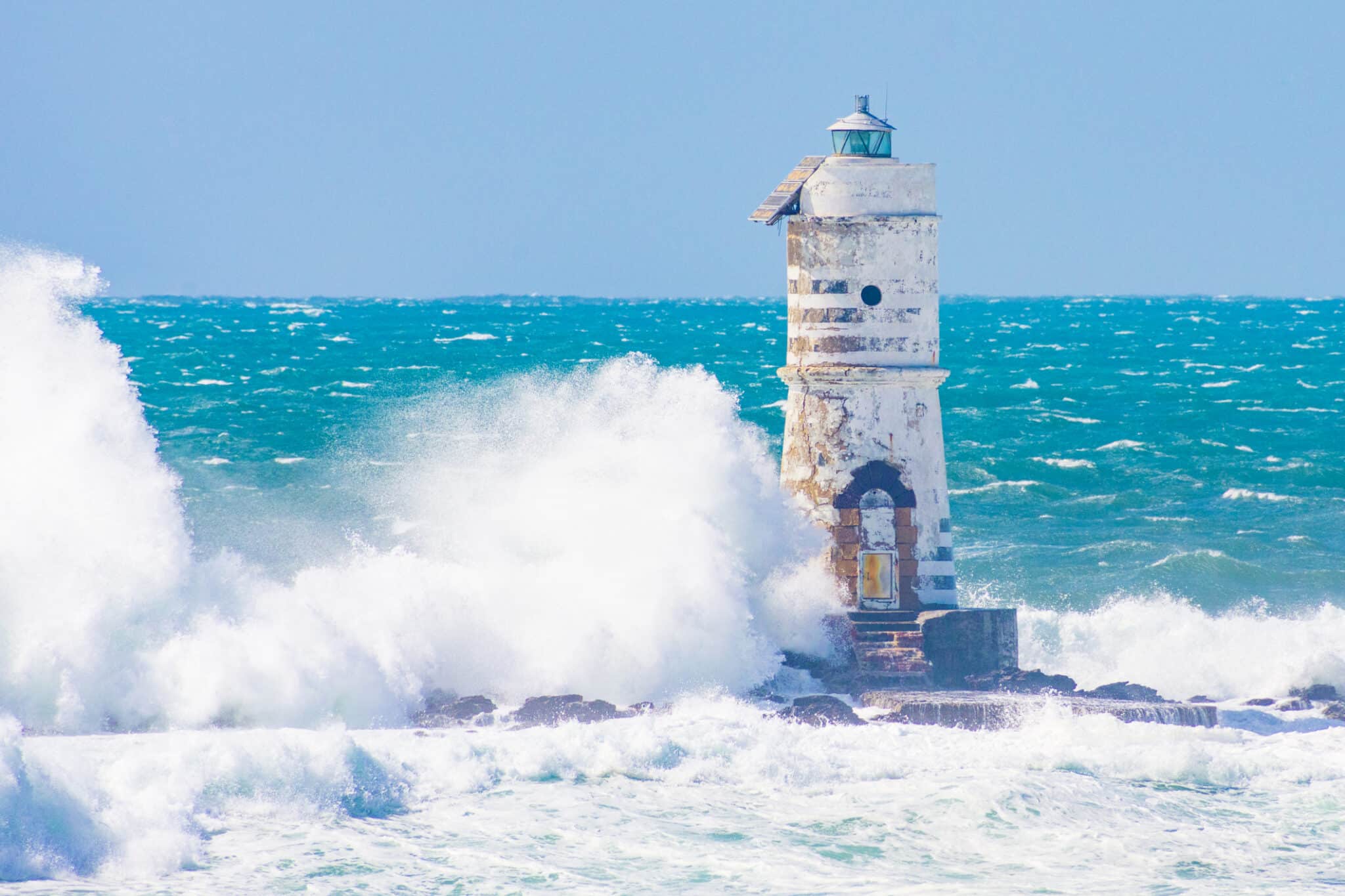 Faro in mare con onde schiumose