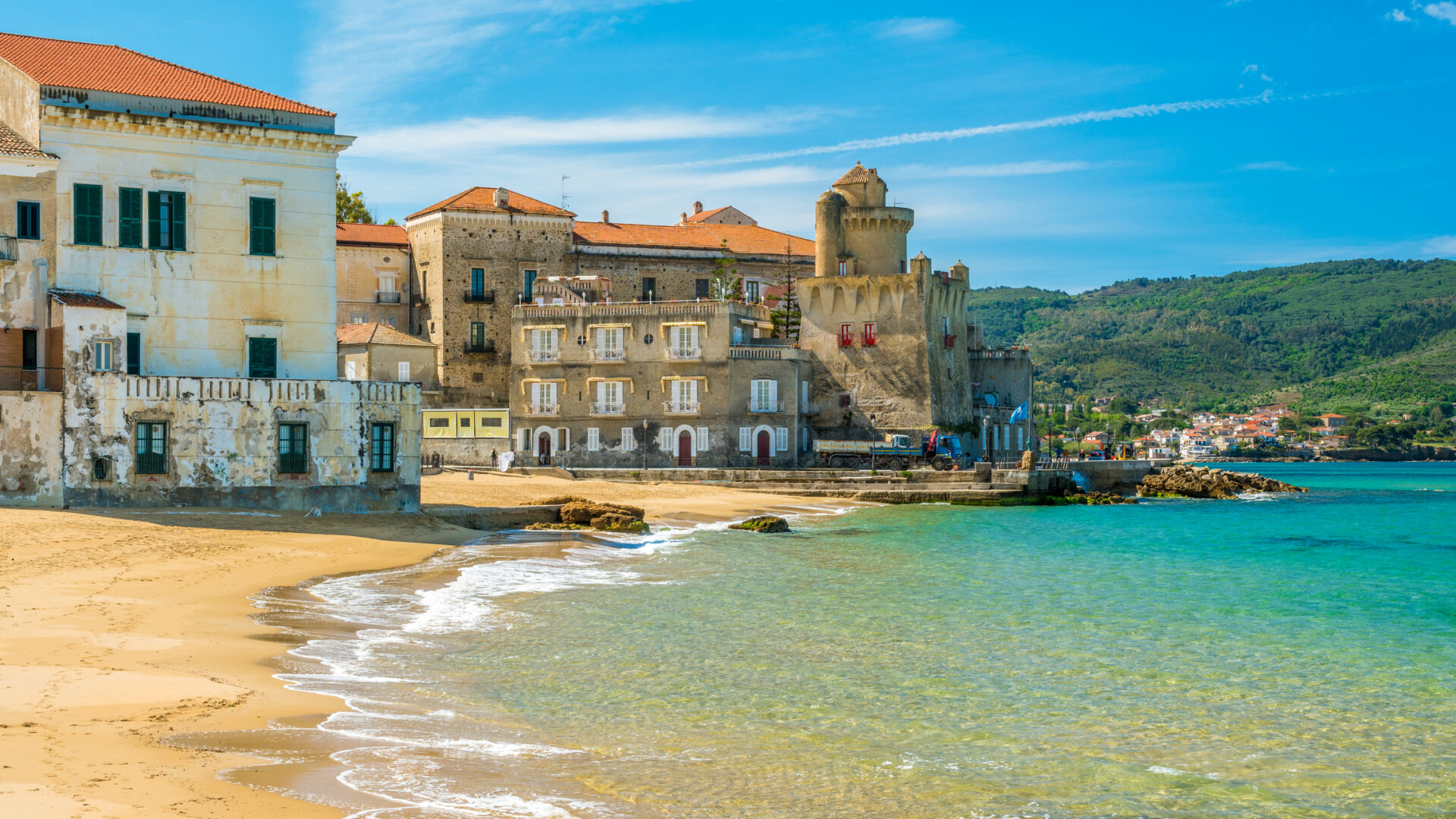 Paysage côtier avec des bâtiments historiques et une mer cristalline