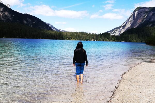 Person spaziert am Bergseeufer