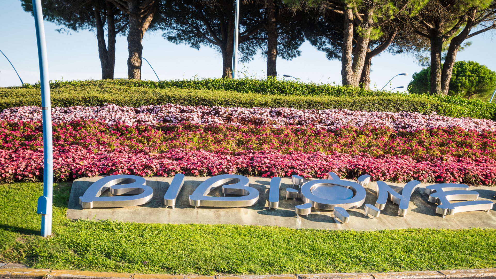 Scultura 'BIBIONE' tra fiori colorati e alberi