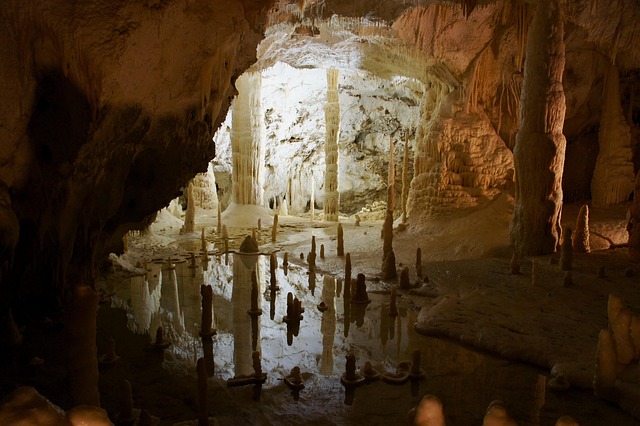 Caverna con stalagmiti e stalattiti illuminate