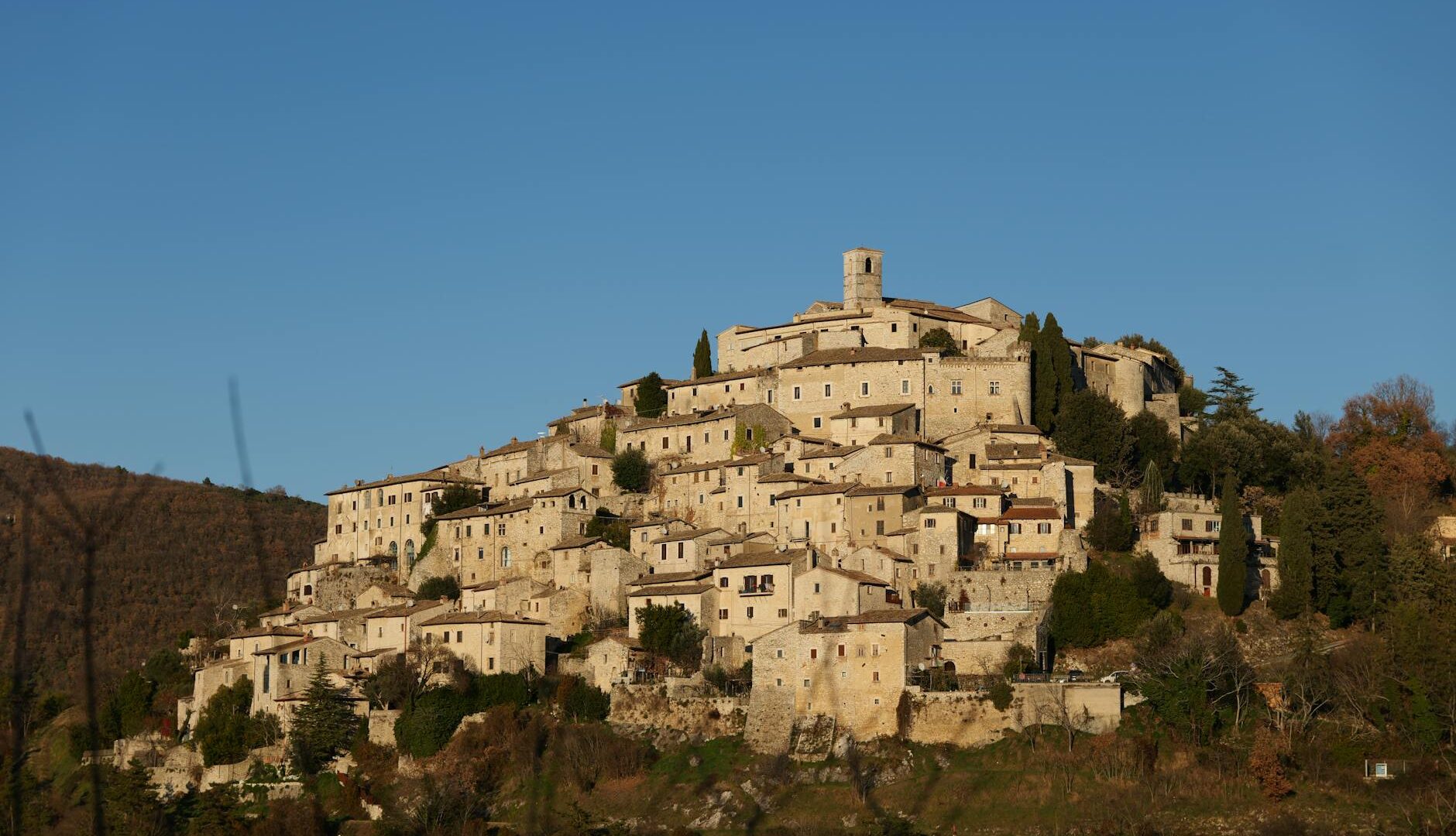 Antico borgo medievale su collina al tramonto