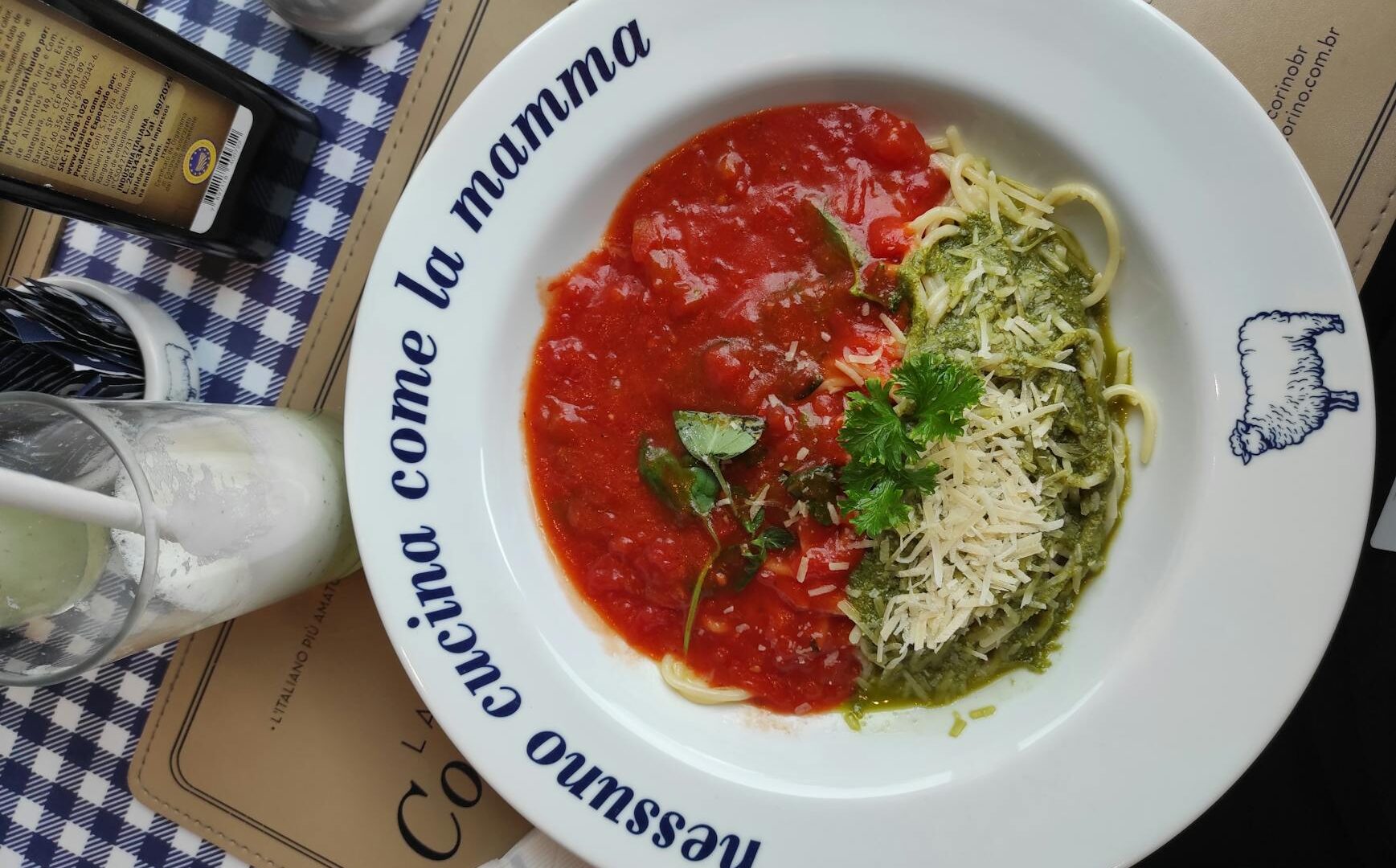 Pasta metà rossa e metà verde su piatto bianco.