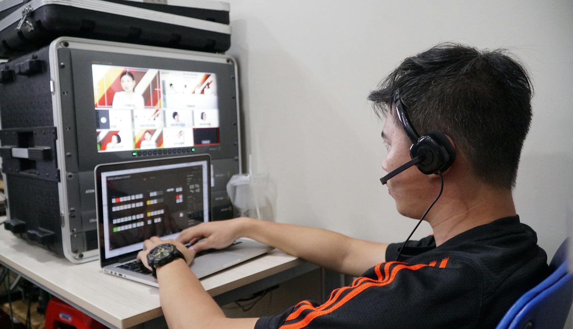 Operatore con cuffie gestisce apparecchiature audiovisive