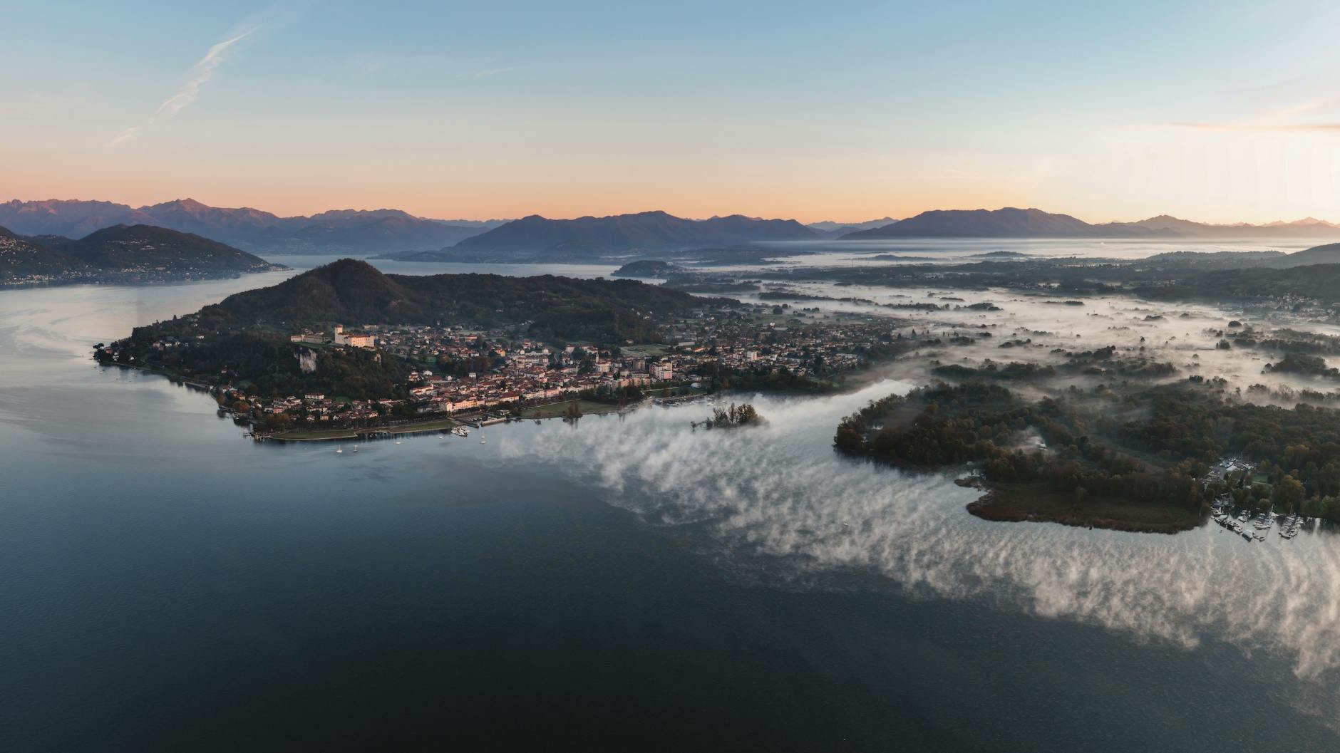 Panorama lacustre all'alba con montagne
