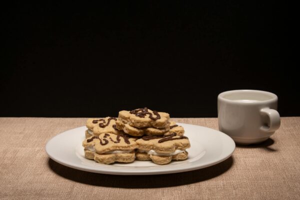 Biscotti glassati con tazza di caffè sul tavolo.