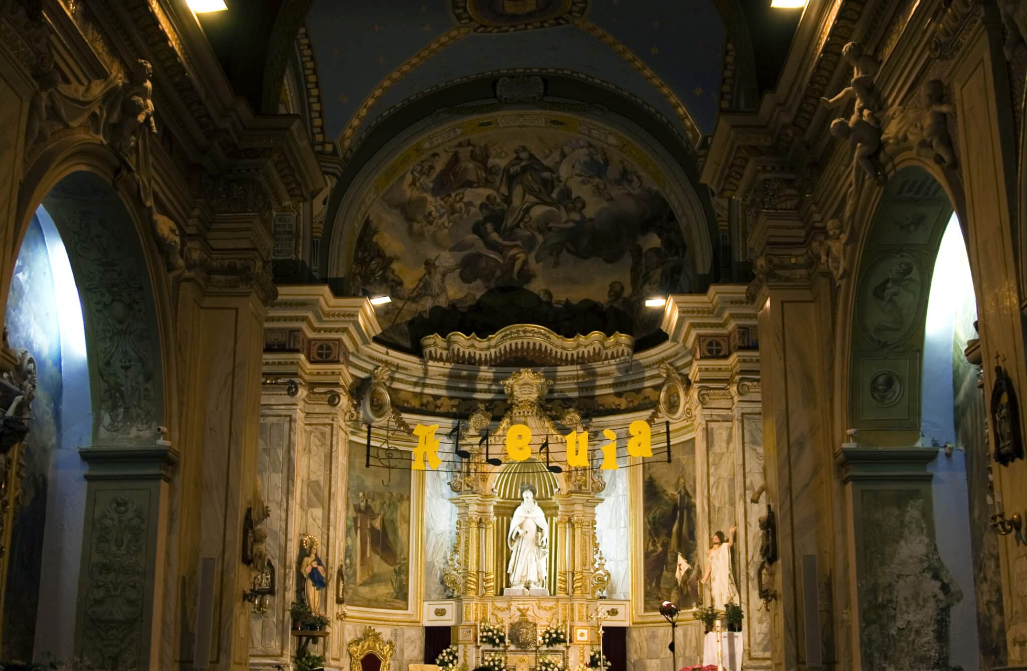 Interno chiesa barocca con altare e affreschi.