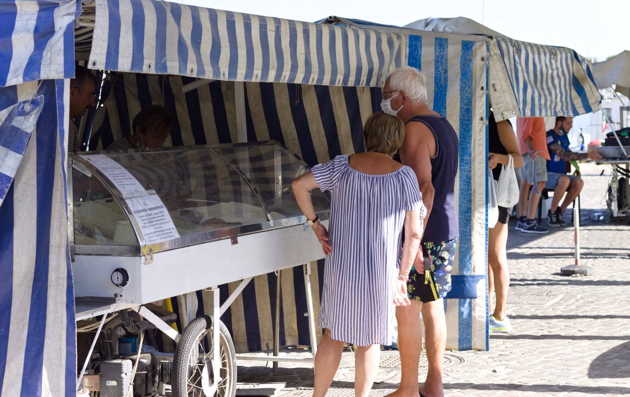 la coppia sta comprando il pesce al mercato di strada. Pesaro