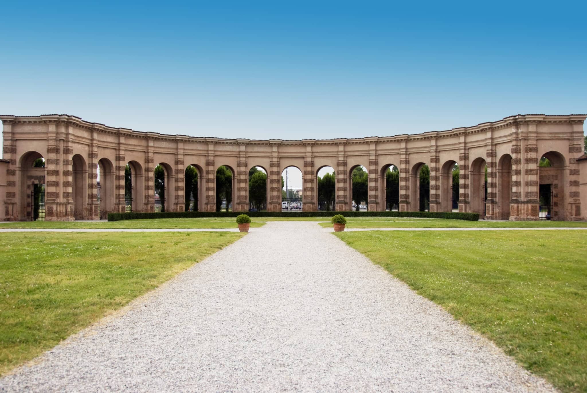 Viale con arco colonnato in parco verde