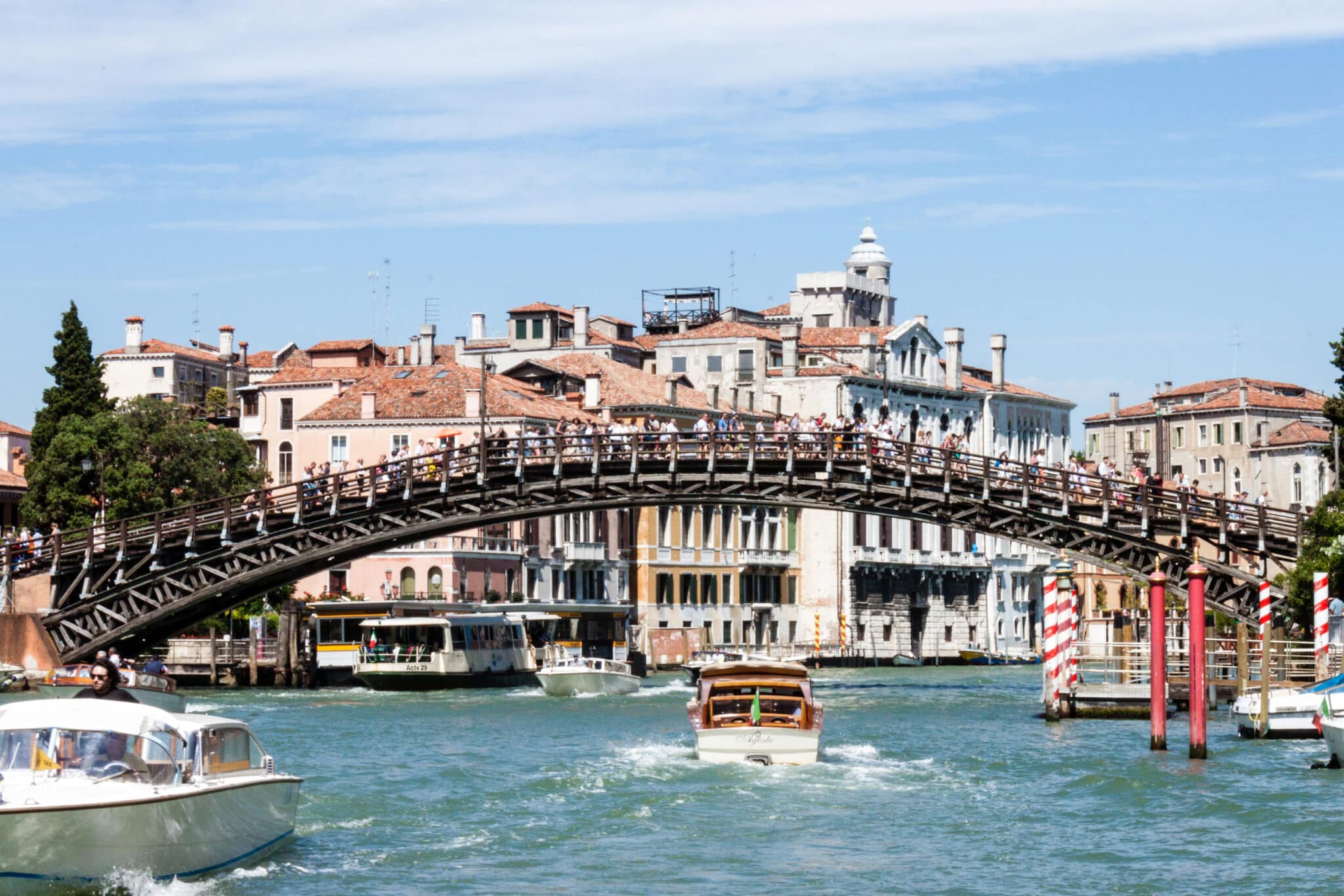 Ponte Accademia a Venezia con barche e turisti.