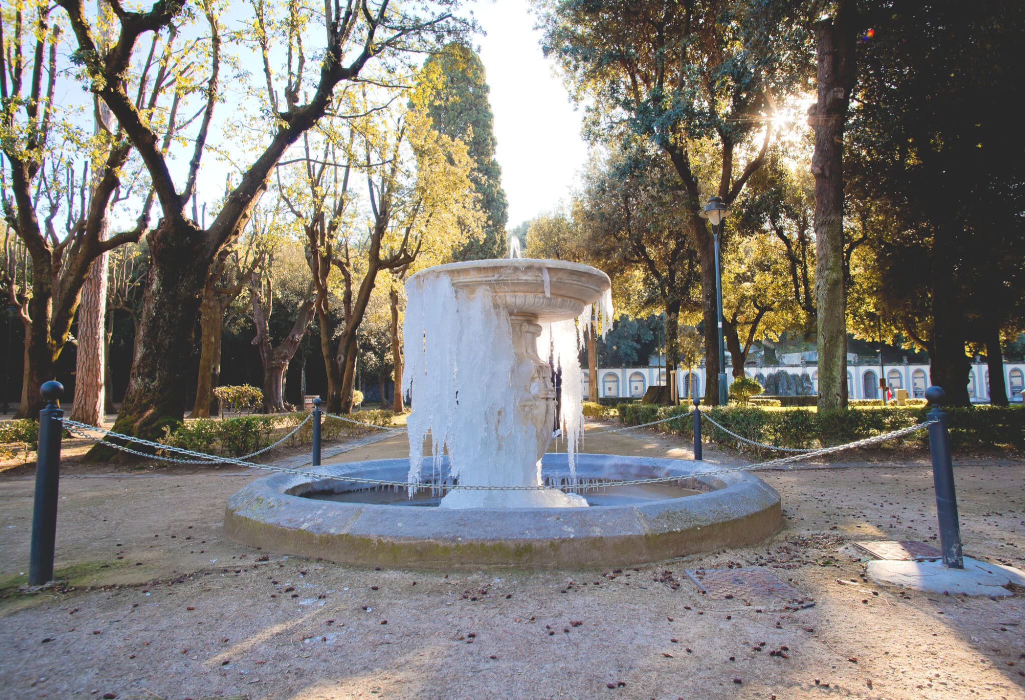 Fontana ghiacciata in parco soleggiato.