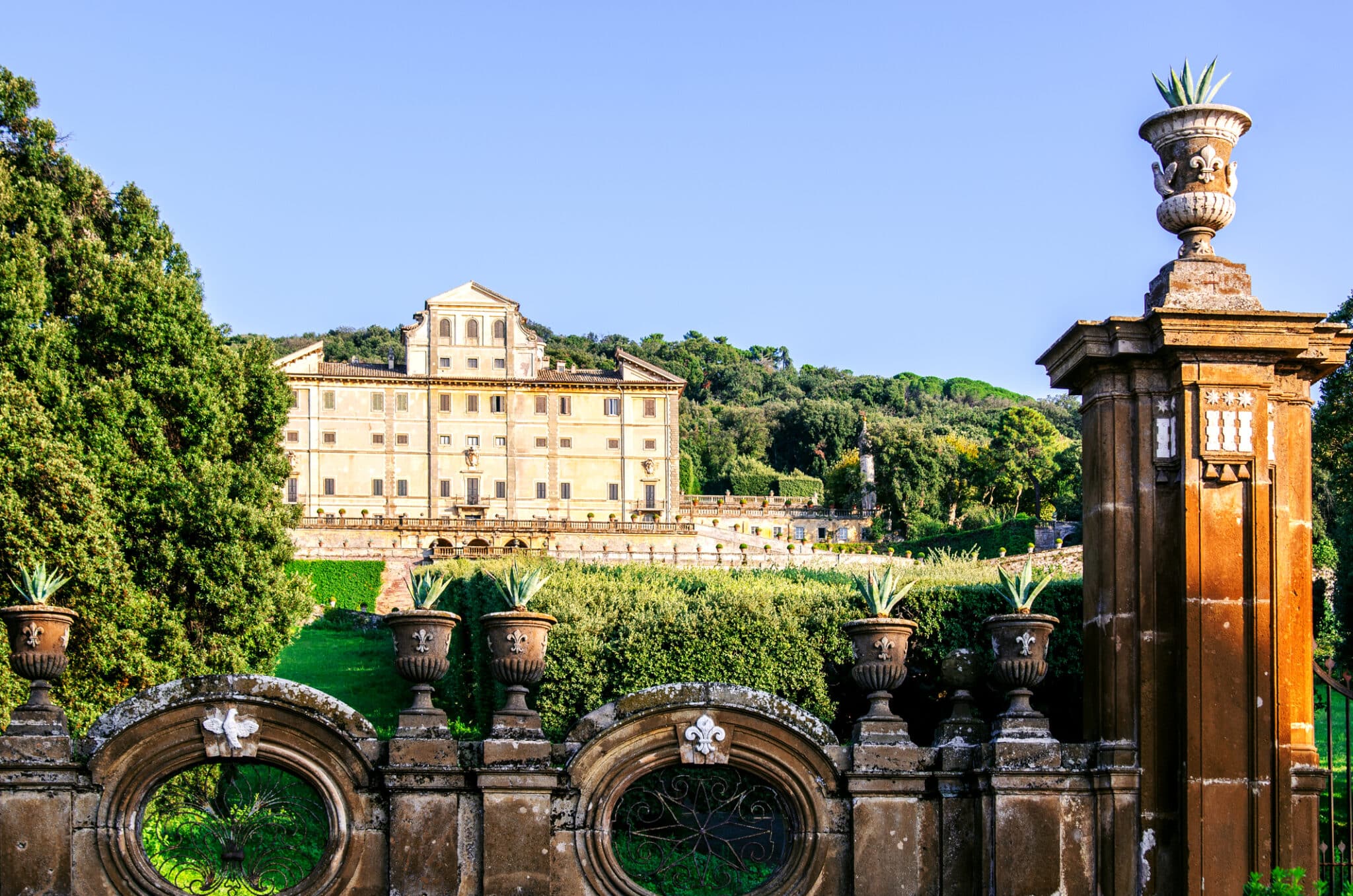Villa storica italiana con giardino e colonne ornamentali.