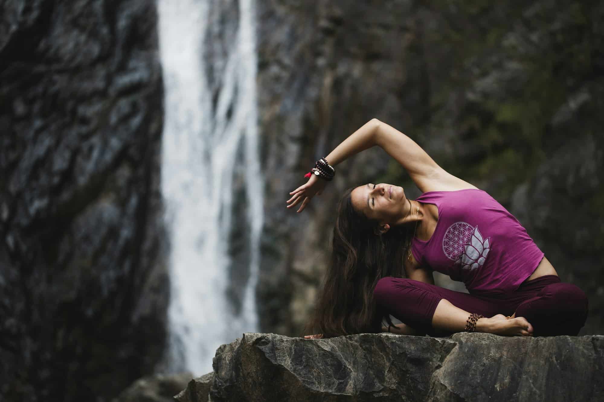 L'Italia, Lecco, donna che fa pratica di yoga vicino ad una cascata