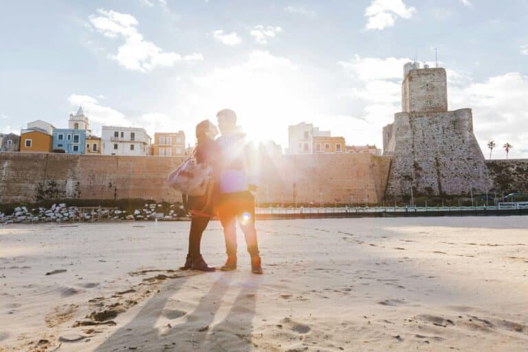 Italy, Molise, Termoli, young couple in the beach at sunrise