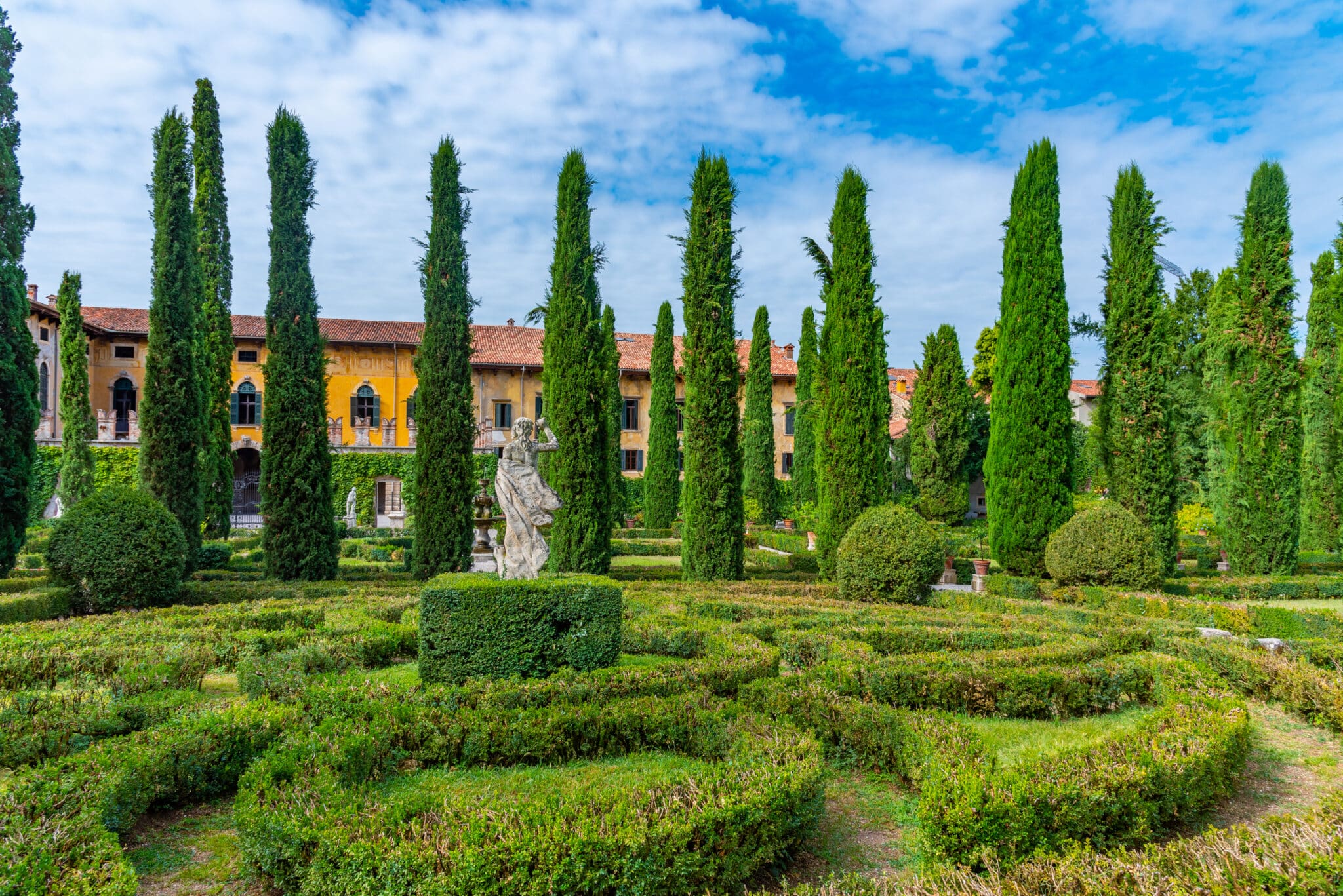 Giardino italiano con siepi e villa antica.