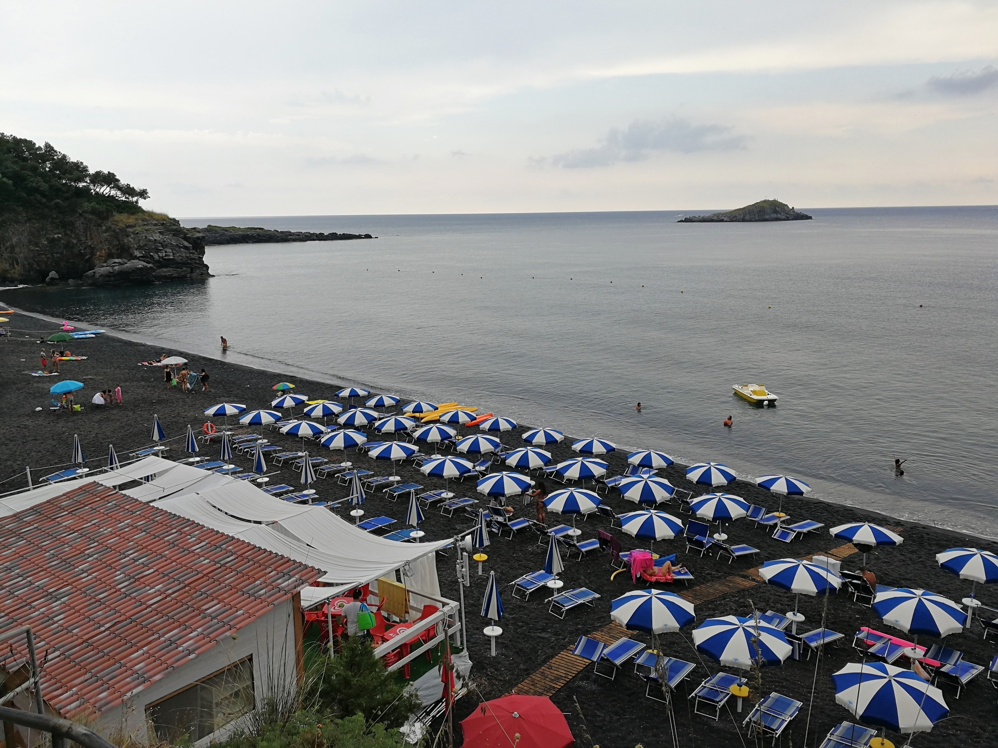 配有遮阳伞和平静海面的意大利海滩。