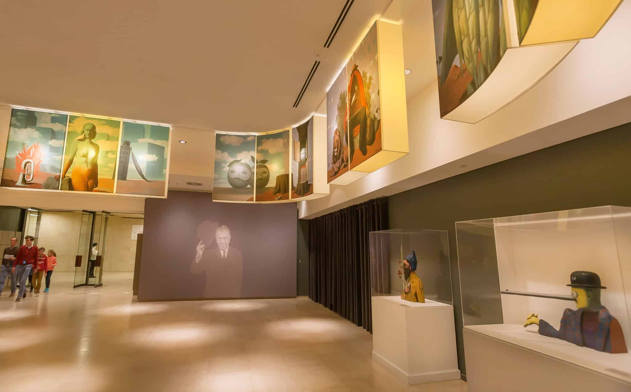 Galleria d'arte moderna con visitatori e opere esposte.