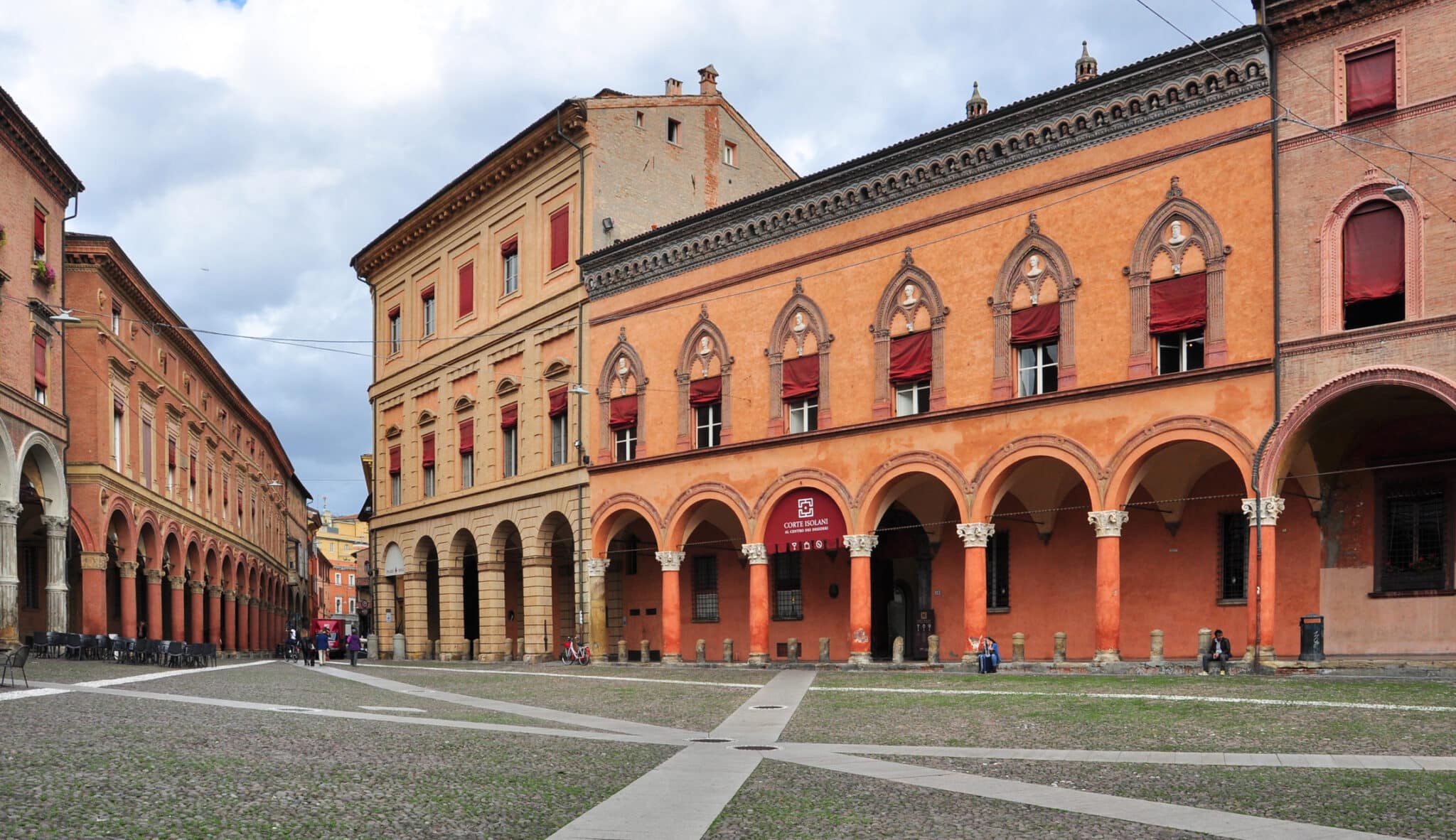 Piazza italiana con portici architettonici e persone.
