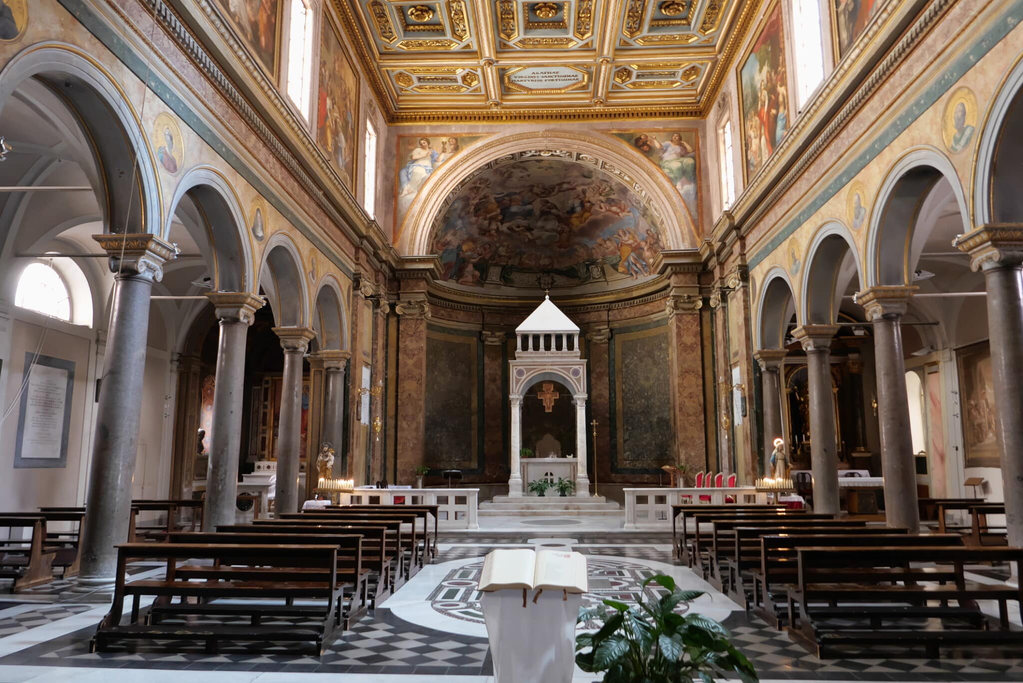 Intérieur de l'église baroque avec fresques et autel.