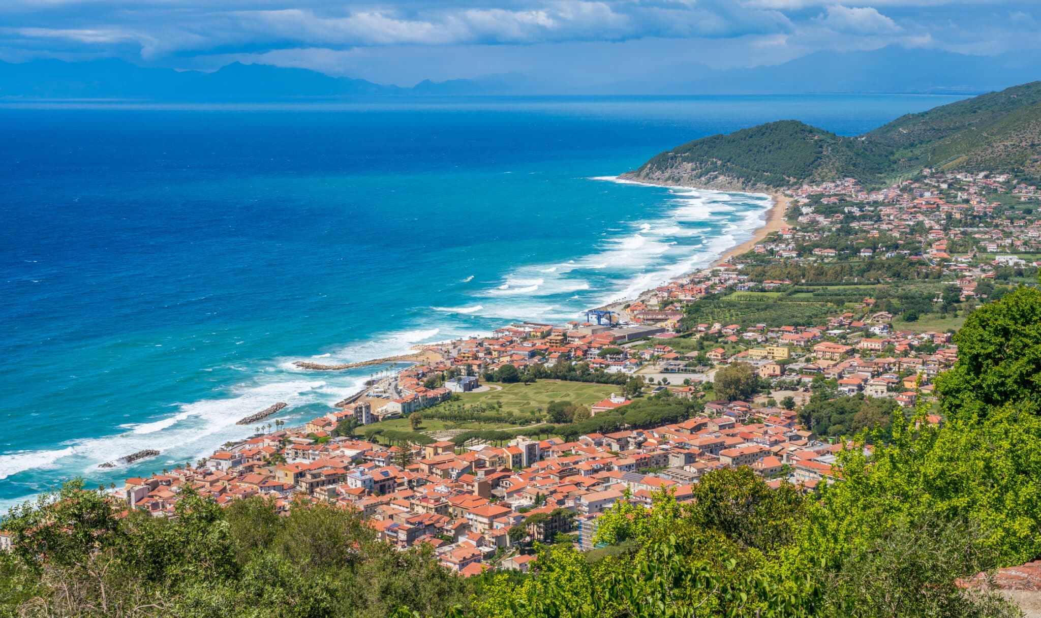 Costiera italiana con spiaggia e case panoramiche.