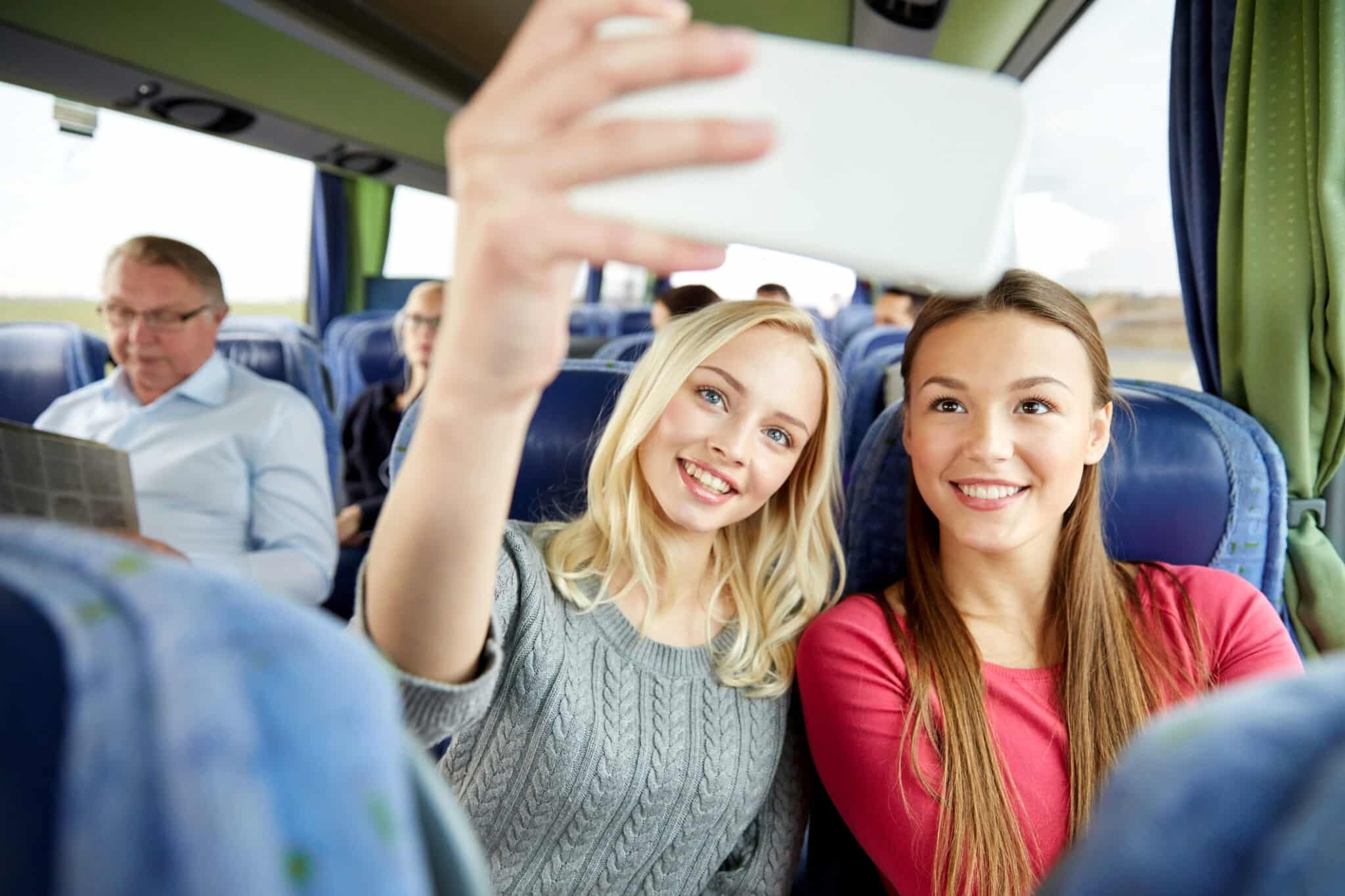Due ragazze che scattano un selfie in autobus.