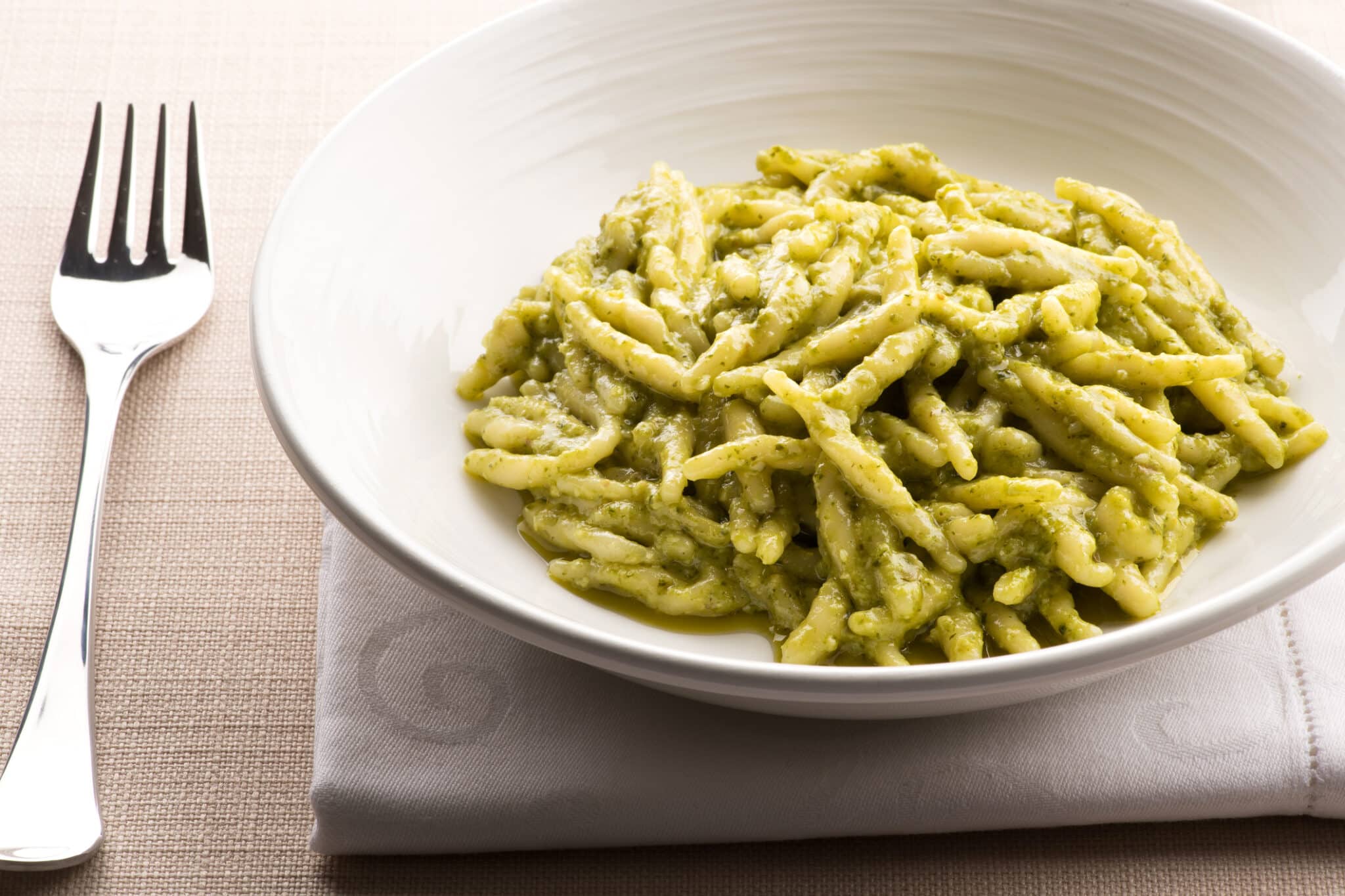 Trofie liguri al pesto fresco. Trofie liguri, Trofie al pesto, con pesto fresco servito come antipasto in una ciotola bianca con tovagliolo e forchetta per la tradizionale cucina regionale italiana