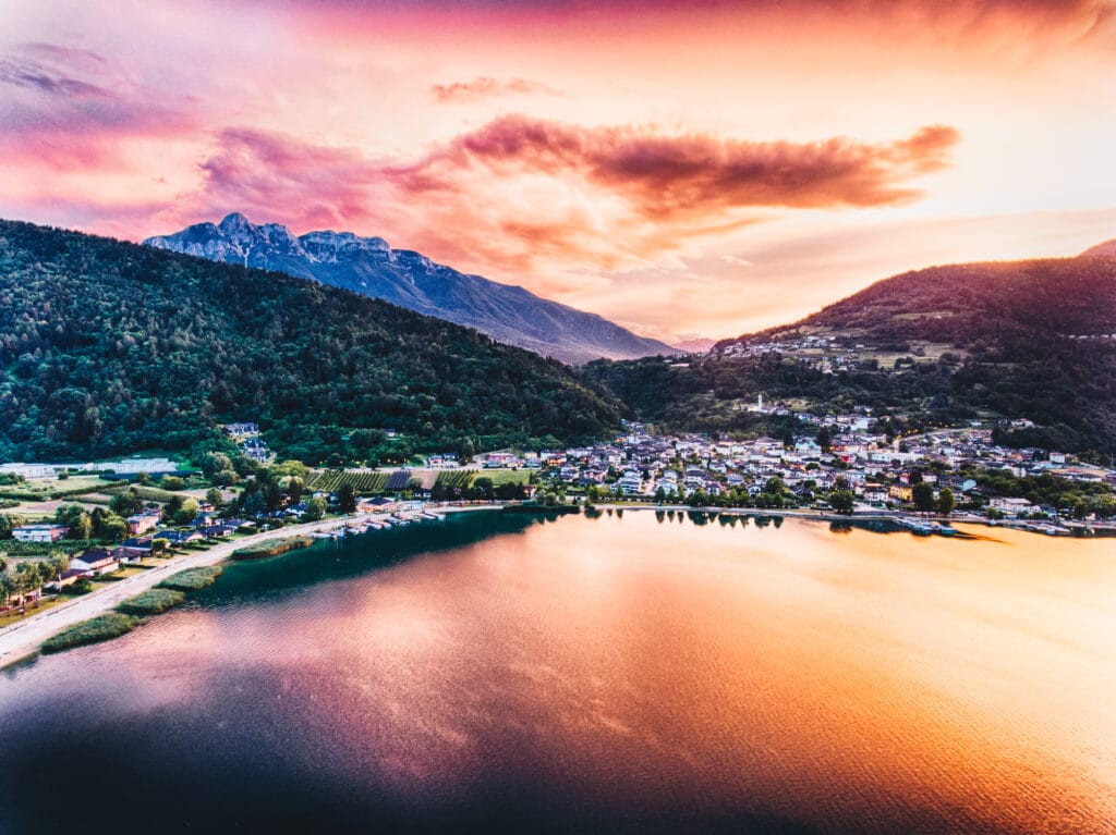 Lebendiger Sonnenuntergang über einem See und Bergen.