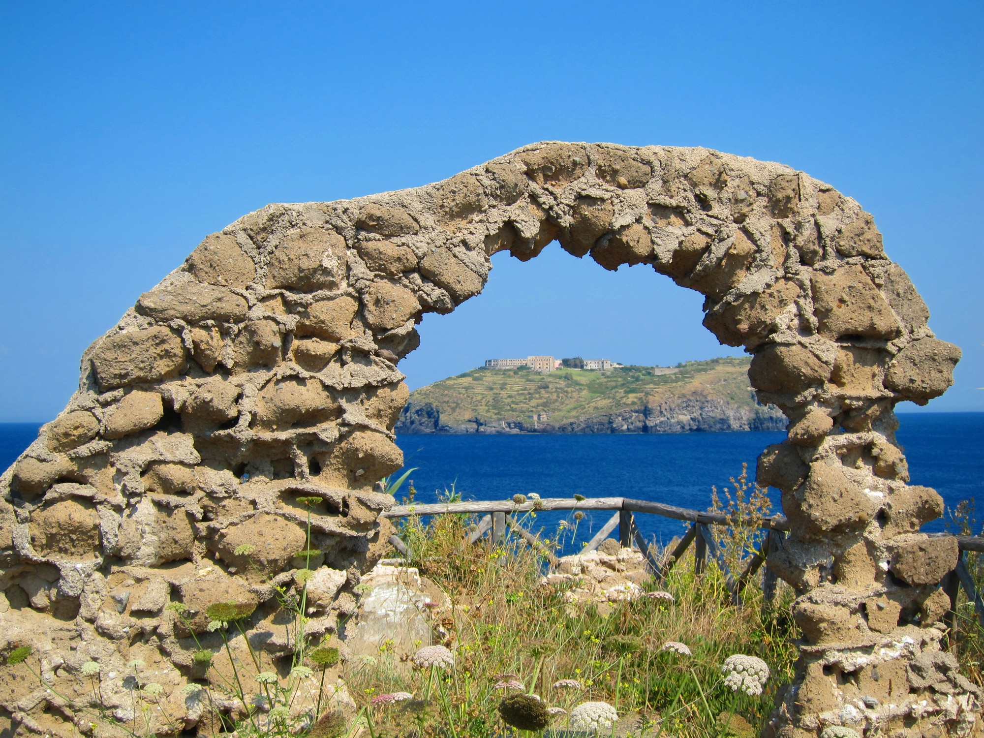 Arco di roccia antico con vista mare blu