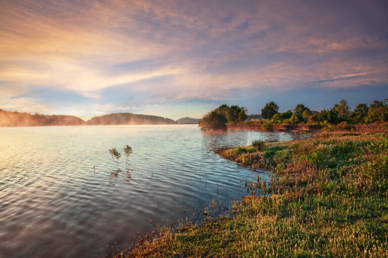 Aube brumeuse sur le lac avec ciel coloré